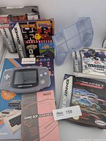 Overview showing console, four game boxes, EZ Grip holder, encyclopedia book, instruction booklet