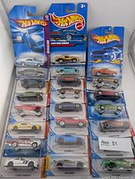 Two columns of 18 carded Hot Wheels cars displayed front view