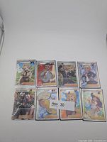 Eight Pokémon Trainer cards laid out in two rows, all in protective sleeves/toploaders