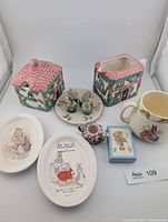 Group shot of entire lot including plates, cottage-ware sugar and creamer, Bunnykins mug, figurines, candle holder and card set