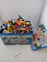 Tin open showing large quantity of Disney mini figurines