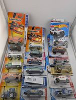 Full lot view showing all 18 carded Hot Wheels and Matchbox vehicles