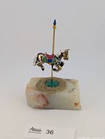 Front view of enamel carousel horse on onyx base showing colours and signature