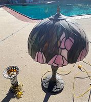 Large and small stained glass lamps beside pool showing size and cords
