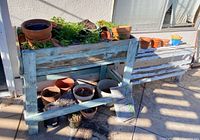 Overall view of raised planter, smaller planter-stand and assorted pots