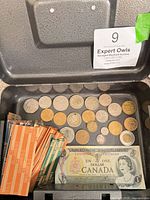 Open metal cash box showing coins, bill, wrappers
