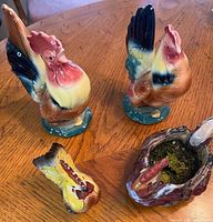 Group shot of all four ceramic rooster pieces on table