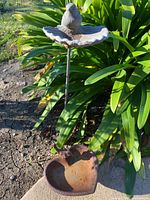 Overall view showing both bird baths – stake model with grey scalloped dish and bird, and separate rusted heart-shaped iron dish