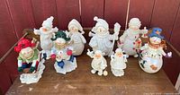 Group view of all nine snowman and Santa themed figurines on table