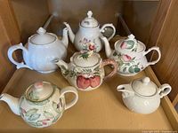 Front view of all six teapots on shelf