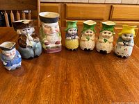 Group view of all seven ceramic Toby jugs and Dutch girl creamers