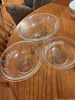 Top view of three clear Pyrex bowls showing floral pattern and interior