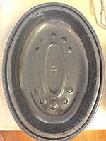 two nested oval black speckled enamel roasting pots