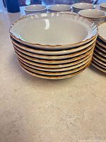Stack of cream bowls with brown rim
