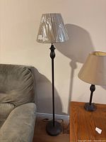 Full view of metal floor lamp beside sofa and table lamp