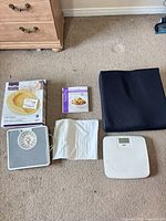 Group shot showing both scales, boxed bedpan, book, seat cushion, heating pad