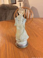 Front view of frosted light-up angel figurine on wood table