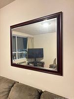 Front view of rectangular wall mirror mounted above sofa