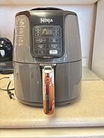 Front view of Ninja air fryer showing control panel and basket handle