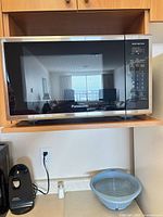 Front view of Panasonic microwave showing control panel, door, and exterior finish