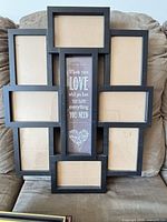 Front view of seven-opening black collage frame holding cardboard inserts