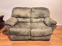 Front view of olive green reclining loveseat in upright position