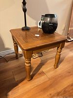 Full view of square side table showing turned legs and oak finish