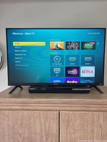 Front view of Hisense Roku TV on cabinet