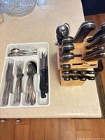 Farberware knife block beside cutlery tray with utensils