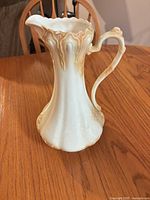 Full view of porcelain pitcher showing colour and relief design