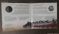 Open bilingual display card showing coin cavity and informational text