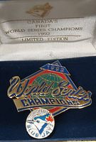 Close-up of enamel pin inside box showing design and text