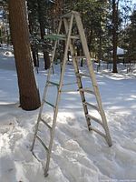 Side view of aluminum A-frame ladder standing in snow