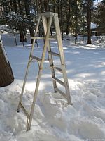 Side view of aluminum A-frame ladder set up in snow