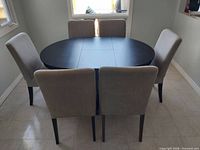 Dining set showing table in oval configuration with six chairs
