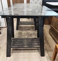 Full length front view of table showing glass top and both A-frame legs