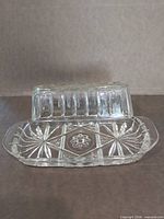 Butter dish base with lid resting vertically shows interior starburst pattern