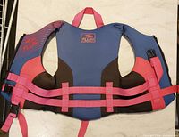 Front of Fluid child life jacket showing blue/black neoprene, pink webbing, arm openings