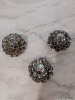 Top view of three silver flower knobs