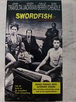 Front cover of Swordfish VHS sleeve showing main cast photo and promotional text