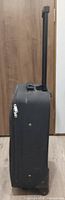 Side profile showing thickness, zipper track, telescoping handle stowed base