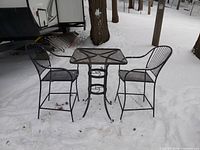 Full view of table and two chairs on snow