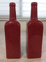Front view of both red speckled ceramic bottles