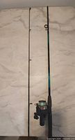 Two-piece rod and attached reel laid flat to show full length and joint