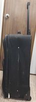 Side profile showing suitcase thickness, fabric exterior and telescopic handle extended