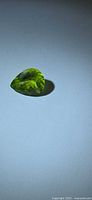 Top view of pear-cut peridot showing apple-green color and facets