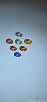 Seven small oval sapphires arranged on light background