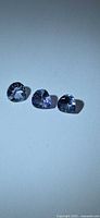 Three pear-cut Tanzanite gemstones on white background