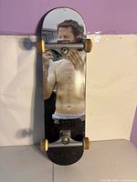 Full view of skateboard front underside showing graphic, trucks and wheels