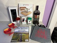 Group shot of all items including boxed products, cork holder, tumbler, books, magazine, ceramic bowls